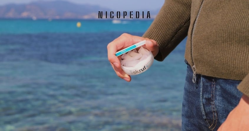 Mann mit einer Dose Nicotine Pouches als Alternative zum Rauchen am Wasser.