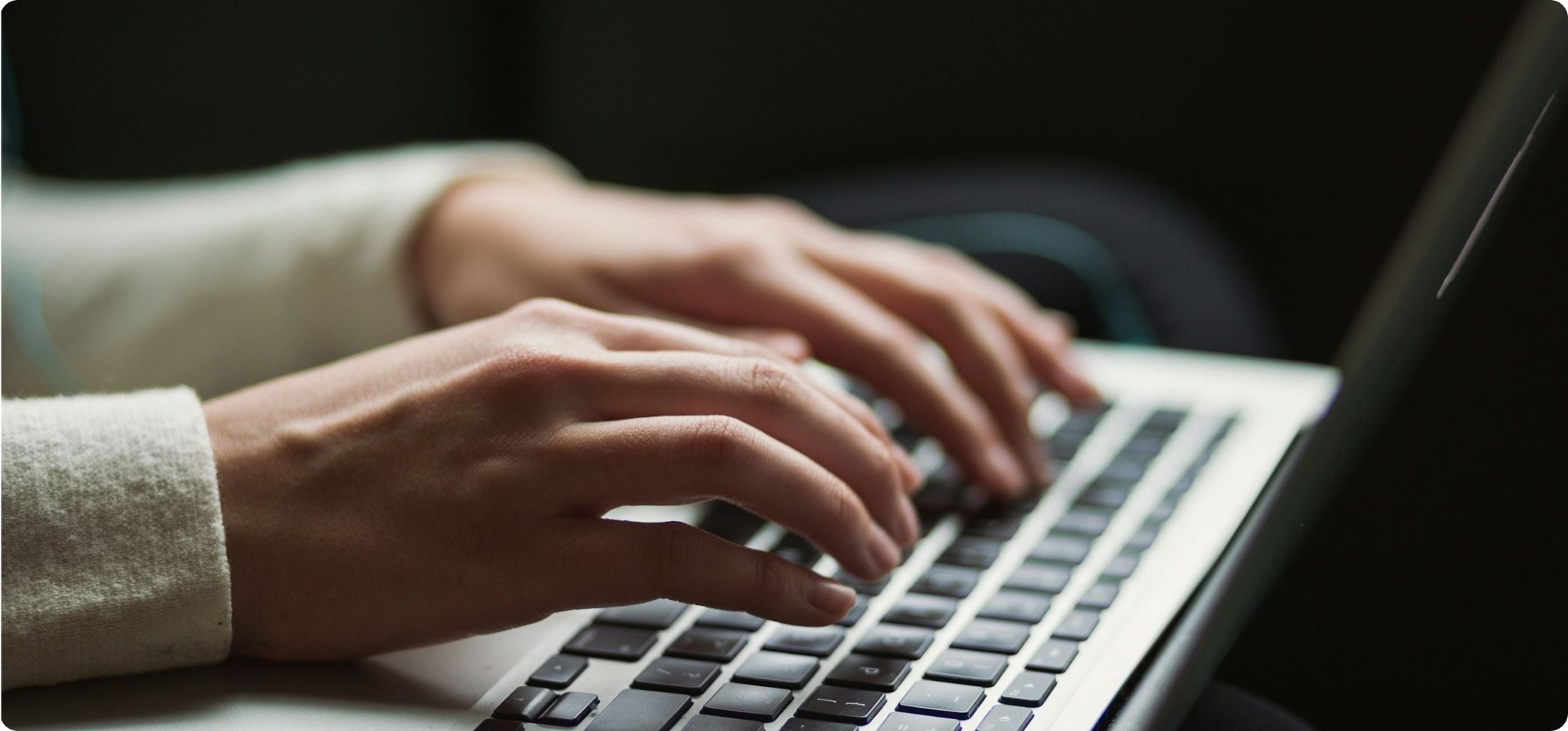 Person tippt auf Laptop-Tastatur