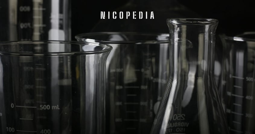 image shows scientific beakers, indicating clinical trial regarding vapes effectiveness over NRTs for quitting smoking