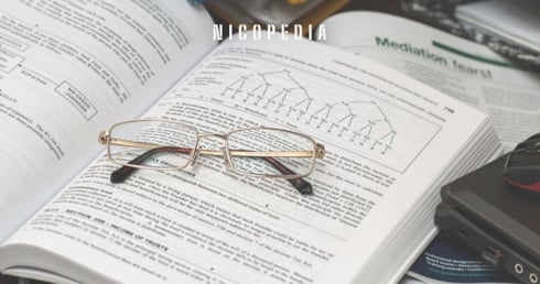a science book with reading glasses on top, symbolising the science behind testing nicotine alternatives