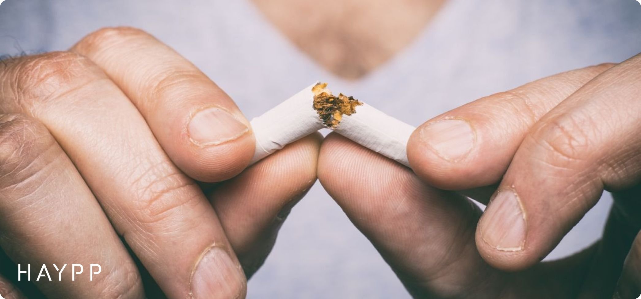 A pair of hands breaking up a cigarette