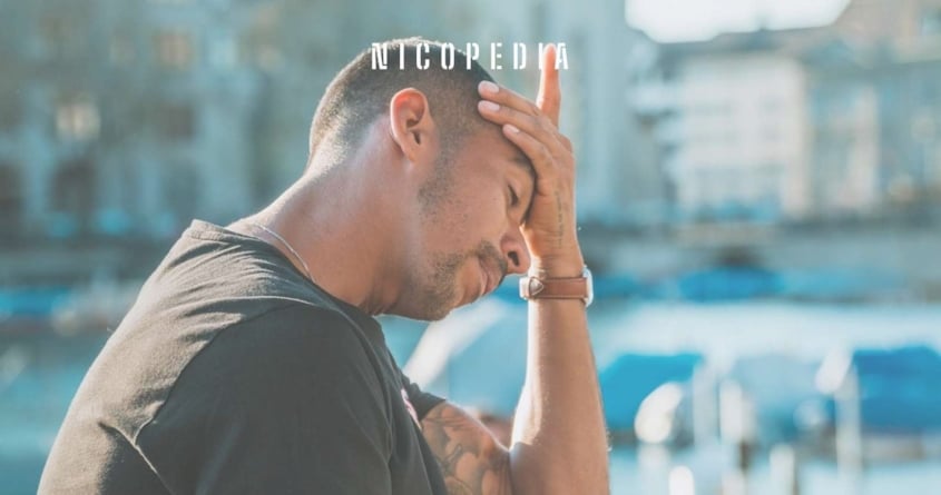 Man holding head as a headache, indicating nicotine poisoning effects