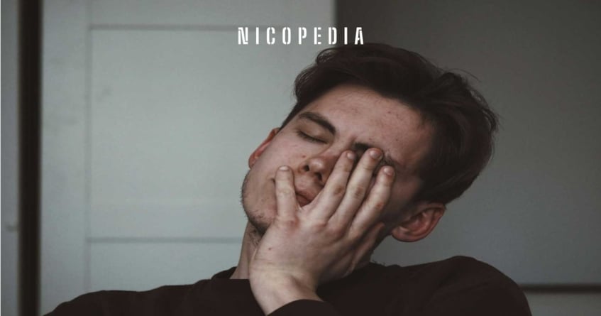 Person holding head as if experiencing a nicotine rush