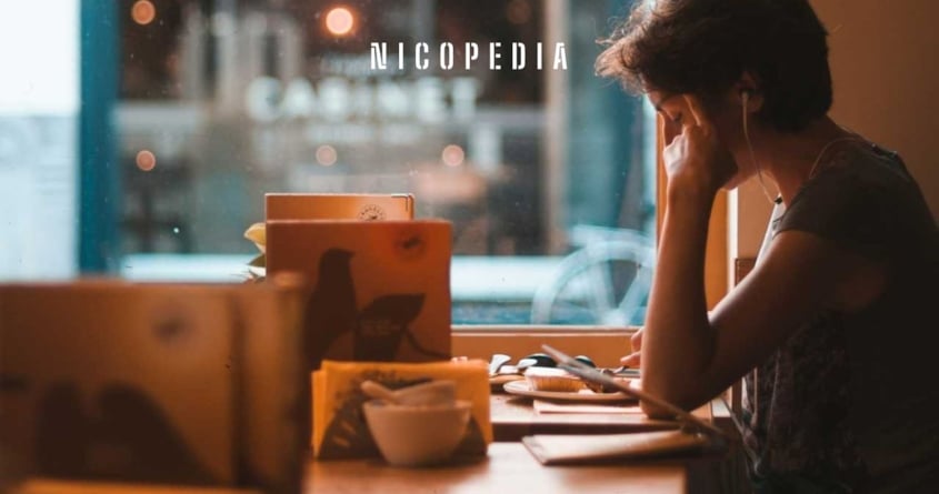 Person concentrating on work in cafe, symbolising nicotine's affect on ADHD symptoms